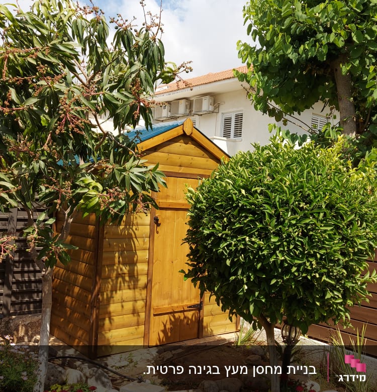 מחסן עץ בגינה עם עצים ופרחים מסביב